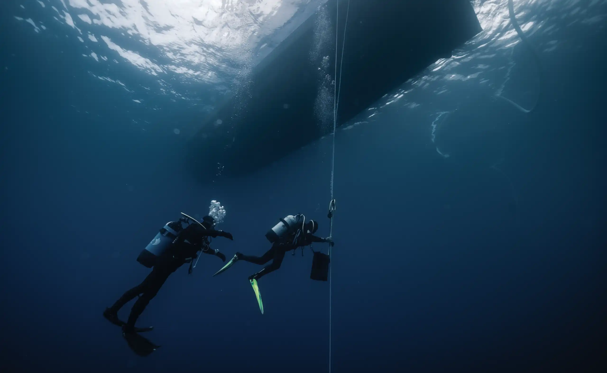 Scuba divers in mid-waters during decompression with the boat above